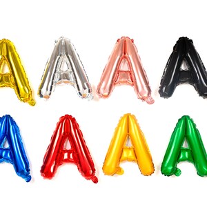 May include: A set of eight foil letter balloons, each in a different color, spelling out the letter "A". The colors are gold, silver, rose gold, black, blue, red, yellow, and green.