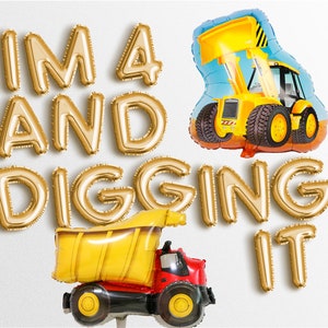 Puede incluir: Globos de lámina dorada que deletrean "I'm 4 and digging it" con dos globos de vehículos de construcción amarillos.