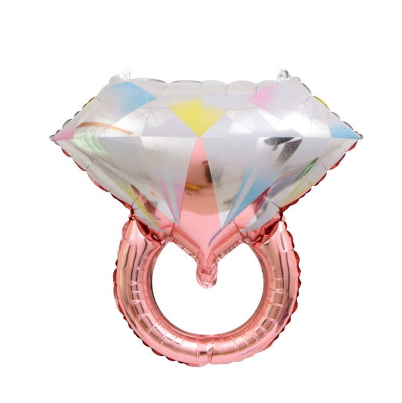 May include: A rose gold foil ring balloon with a large diamond-shaped balloon on top. The diamond balloon has a silver and iridescent finish with colorful accents.