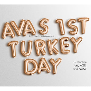 Puede incluir: Globos de letras de lámina dorada que deletrean "Ava's 1st Turkey Day". Personaliza cualquier edad y nombre.