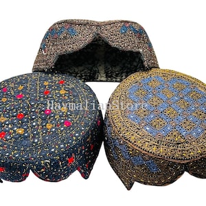 Peut inclure: Trois casquettes brodées de manière complexe dans les tons marron, marine et noir. Les casquettes présentent des motifs détaillés avec des accents colorés, notamment du rouge, du jaune et du bleu. Les casquettes sont présentées sur fond blanc.