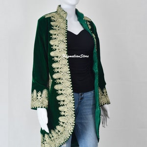 May include: A long, green velvet jacket with gold embroidery. The jacket has a mandarin collar and a long, flowing silhouette. The embroidery is intricate and detailed, and it adds a touch of elegance to the jacket.