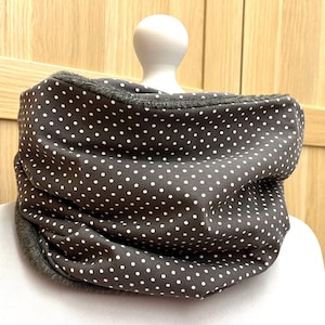 Könnte beinhalten: Ein grauer und weißer Tupfen-Halswärmer mit weichem, flauschigem Futter.