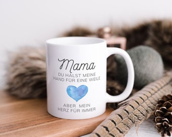 Könnte beinhalten: Weiße Keramiktasse mit einem blauen Aquarellherz und dem Text "Mama Du hältst meine Hand für eine Weile Aber mein Herz für immer".