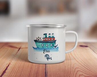 May include: White enamel mug with a blue and green watercolor illustration of a ship with red accents and the name "Elias" printed below. A small blue whale is swimming below the ship.