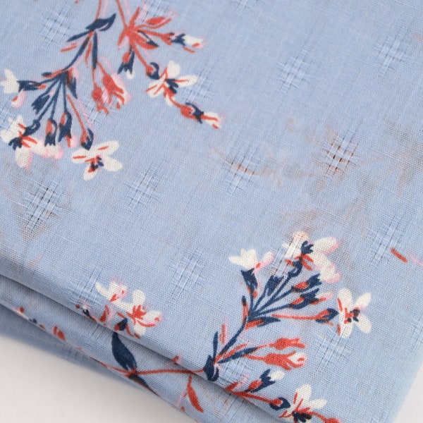 Tissu en coton bleu clair avec des fleurs au mètre tissu tissé
