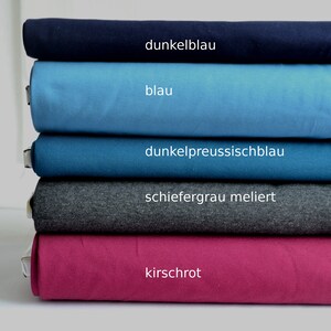 K&ouml;nnte beinhalten: Ein Stapel aus f&uuml;nf gefalteten Stoffballen in verschiedenen Farben. Die Farben von oben nach unten sind als dunkelblau, blau, dunkelpreussischblau, schiefergrau meliert und kirschrot beschriftet. Jeder Stoffballen ist ordentlich horizontal geschichtet.