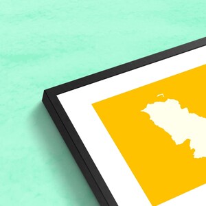 Puede incluir: Una impresi&oacute;n art&iacute;stica enmarcada con un contorno de mapa crema sobre un fondo amarillo brillante. La impresi&oacute;n est&aacute; enmarcada en un passe-partout blanco y un marco negro, contra una pared verde claro.