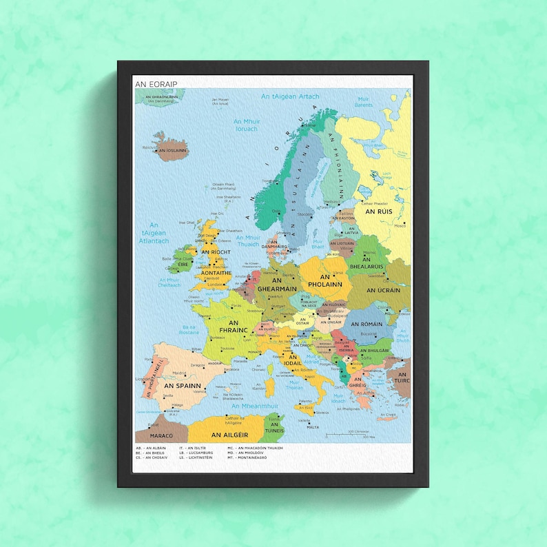 Pu&ograve; includere: Una mappa colorata dell'Europa con i nomi dei paesi in gaelico irlandese. La mappa &egrave; incorniciata in nero e ha uno sfondo blu chiaro. I paesi sono colorati in tonalit&agrave; di verde, giallo, arancione e marrone.