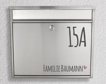 May include: A silver mailbox with a black number "15A" and the text "Familie Baumann" with a pink heart.