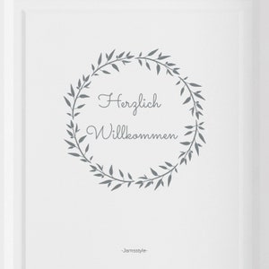 May include: A white background with a grey wreath of leaves and the text "Herzlich Willkommen" in the centre. The text "Jamstyle" is at the bottom of the image.