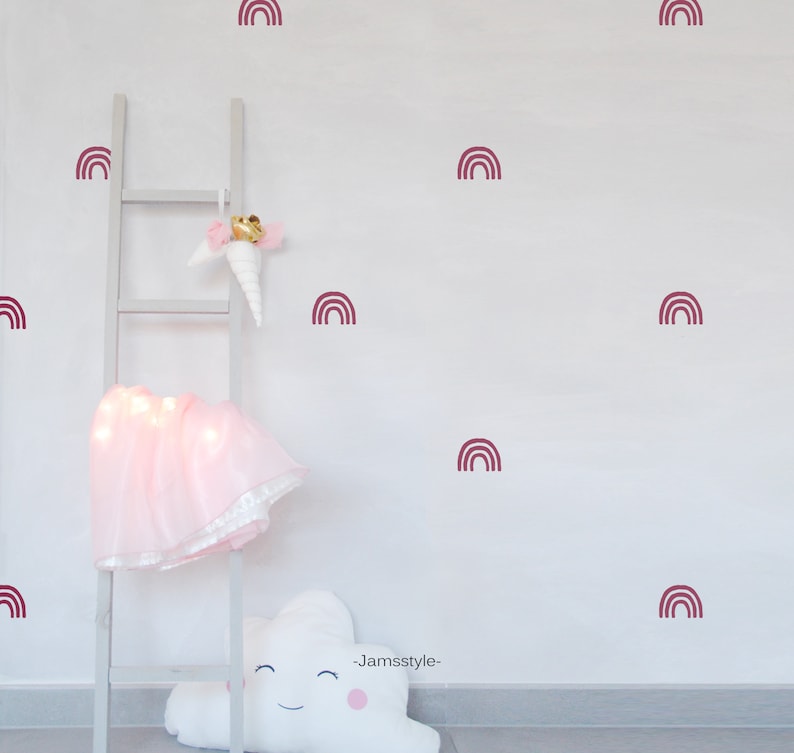 Puede incluir: Una pared blanca con una escalera blanca y una falda de tut&uacute; rosa. La pared est&aacute; decorada con calcoman&iacute;as de arco&iacute;ris burdeos. El texto "_Jamssstyle_" est&aacute; escrito en la pared.