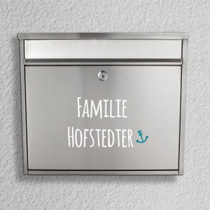 May include: A silver mailbox with the text "Familie Hofstedter" and a blue anchor symbol.