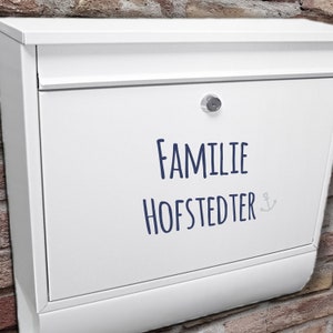 May include: White mailbox with a blue inscription that reads "Familie Hofstedter" with a small anchor symbol.