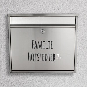 May include: A silver mailbox with the text "FAMILIE HOFSTEDTER" and a small anchor symbol.