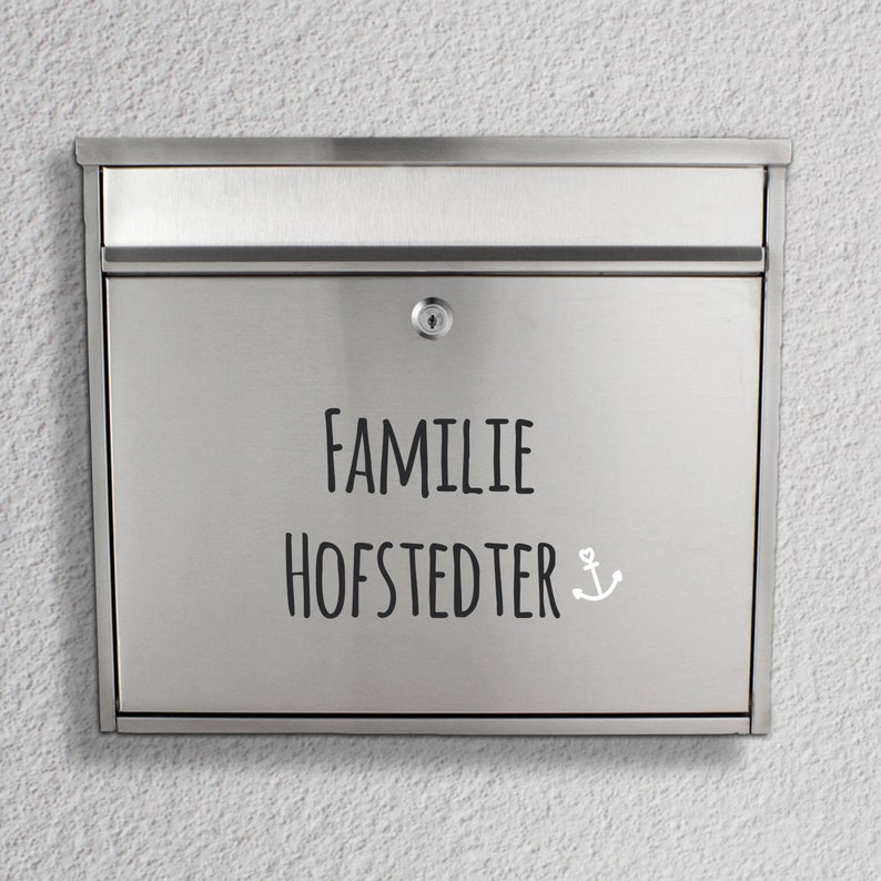 May include: A silver mailbox with the text "FAMILIE HOFSTEDTER" and a small anchor symbol.
