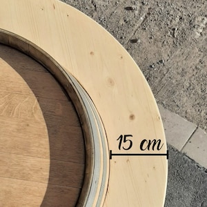May include: A wooden round table top with a 15 cm diameter. The table top is made of light wood and has a dark wood ring around the edge.