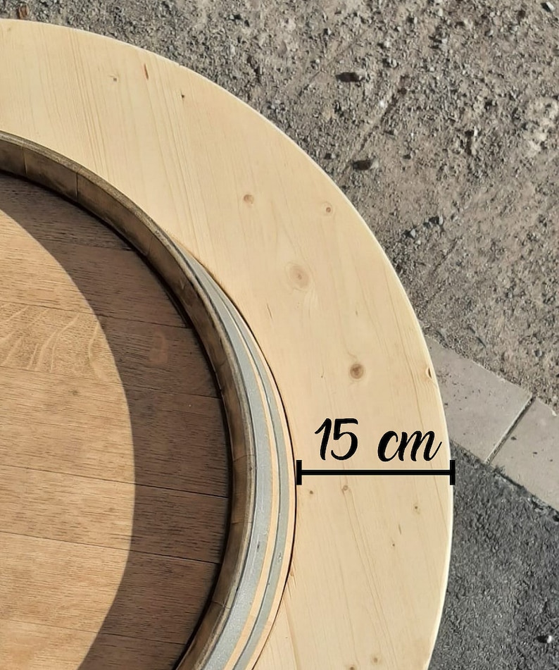 May include: A wooden round table top with a 15 cm diameter. The table top is made of light wood and has a dark wood ring around the edge.