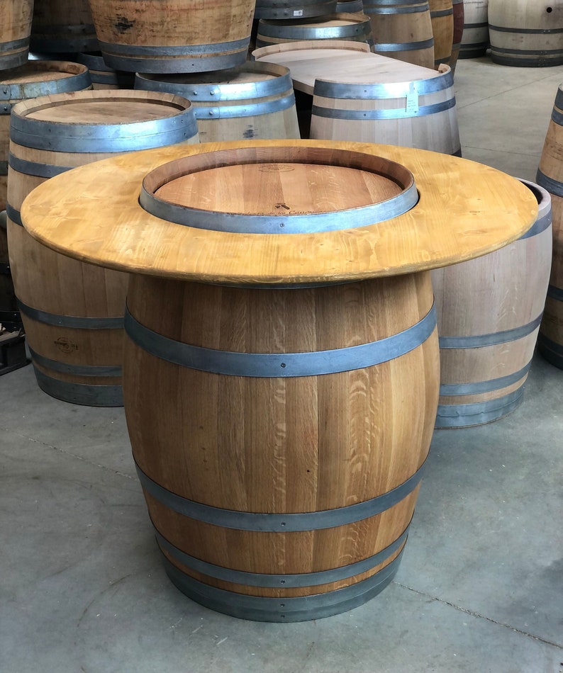 May include: A wooden barrel table with a round top and metal bands. The table is made from a single barrel and has a natural wood finish.