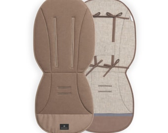 Puede incluir: Dos forros de asiento de cochecito en tonos neutros. Uno es marrón claro liso, el otro es beige claro con ribetes y lazos marrones. Ambos tienen una forma contorneada y están diseñados para la comodidad y el soporte.