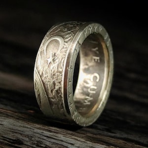 Könnte beinhalten: Ein silberner Ring aus einer wiederverwendeten Münze. Der Ring zeigt ein Design mit einer Mondsichel und einem Stern sowie die Inschrift "CUM YE"