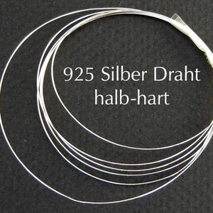 Könnte beinhalten: Ein Bündel Silberdraht, eng gewickelt, vor dunklem Hintergrund. Der Draht ist mit dem Text "925 Silber Draht halb-hart" beschriftet. Der Draht scheint ein Schmuckherstellungsbedarf zu sein.