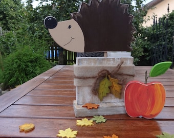 Hedgehog on spruce wood base with apple