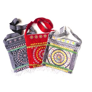 K&ouml;nnte beinhalten: Drei Perlenhandtaschen mit bunten Stickereien und Fransen. Die Taschen sind schwarz, rot und wei&szlig; mit geometrischen und floralen Mustern.