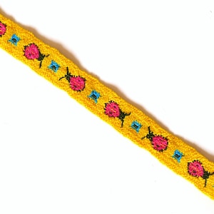 May include: Yellow trim with a repeating pattern of pink flowers and blue accents.