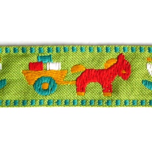 May include: Green ribbon with a repeating pattern of white flowers, a red horse pulling a yellow wagon with colorful blocks, and a turquoise border.