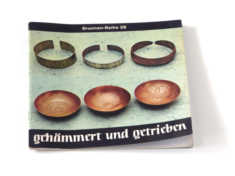 Puede incluir: Una portada de libro con el t&iacute;tulo "gehaemmert und getrieben" en texto negro sobre fondo blanco. La portada presenta seis im&aacute;genes de cuencos y pulseras de cobre.