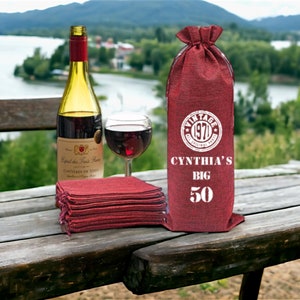 May include: Red burlap wine bottle bag with white text that reads "Vintage 1970 The Original Party", "Cynthia's Big 50".