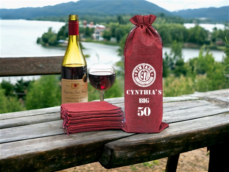 May include: Red burlap wine bottle bag with white text that reads "Vintage 1970 The Original Party", "Cynthia's Big 50".
