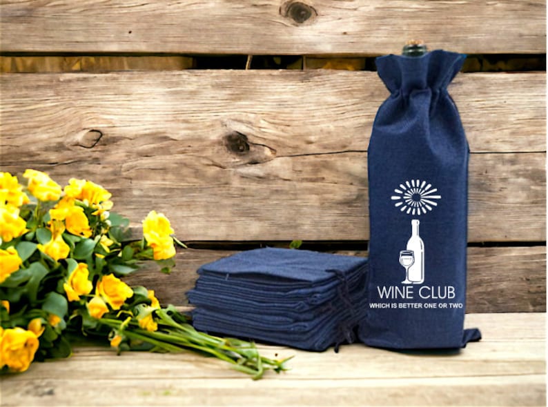 May include: A stack of navy blue wine bottle bags with a white design of a wine glass and bottle with the text "Wine Club Which is better one or two".