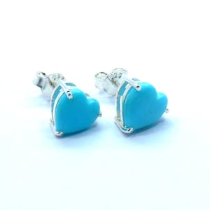 Puede incluir: Un par de pendientes de plata en forma de corazón con piedras turquesa.