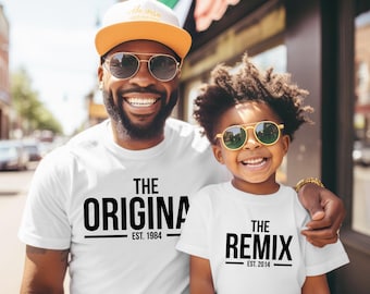 Pode incluir: Duas pessoas vestindo camisetas brancas combinando com texto preto. Uma camisa diz "THE ORIGINAL EST. 1984" e a outra diz "THE REMIX EST. 2014". Ambos usam óculos de sol e estão sorrindo.