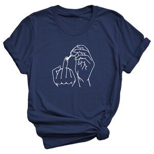 May include: A navy blue t-shirt with a white outline of a hand giving the middle finger and another hand holding a small object.