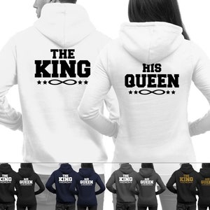Könnte beinhalten: Zwei weiße Kapuzenpullover mit schwarzem Text auf der Rückseite. Ein Pullover sagt "The King" mit einem Symbol eines Unendlichkeitszeichens und Sternen. Der andere Pullover sagt "His Queen" mit einem Symbol eines Unendlichkeitszeichens und Sternen.