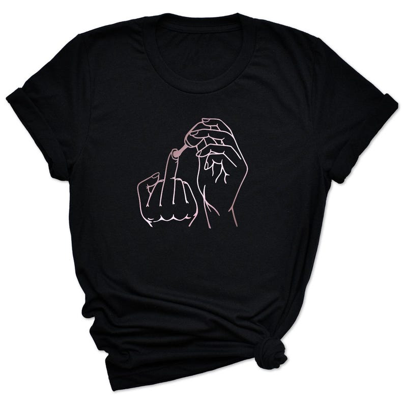 May include: A black t-shirt with a pink line drawing of two hands. One hand is holding a bottle of nail polish and the other hand is giving the middle finger.