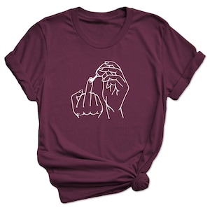 May include: Burgundy t-shirt with a white outline of a hand giving the middle finger and another hand holding a cotton swab.