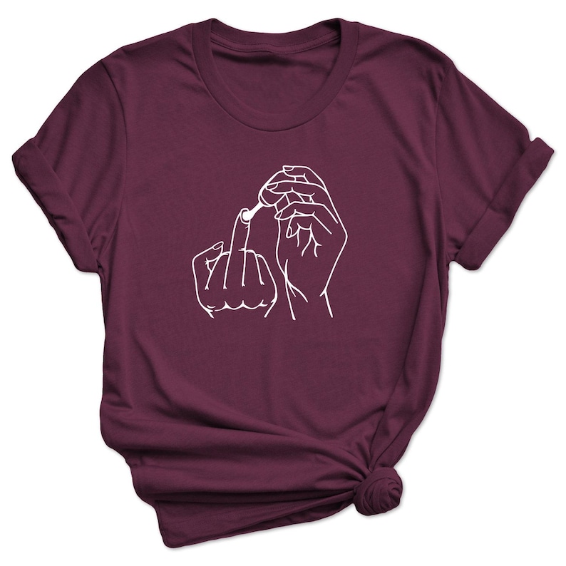 May include: Burgundy t-shirt with a white outline of a hand giving the middle finger and another hand holding a cotton swab.