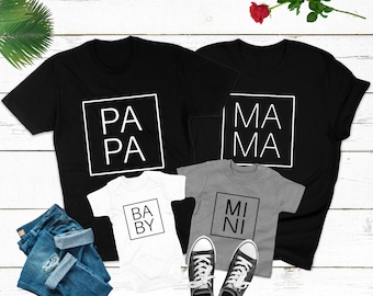 May include: A set of three black and grey t-shirts with white text. The shirts say "Papa", "Mama", "Baby", and "Mini" in a square frame.