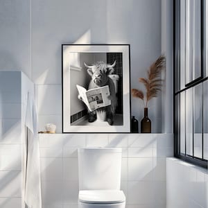 Op de afbeelding: Zwart-witfoto van een Schotse hooglander die op een toilet zit en een krant leest. De krantenkoppen luiden "PROTEST"