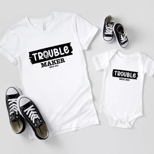 Könnte beinhalten: Weißes T-Shirt und Body-Set mit schwarzem Text "Trouble Maker Since 2024".