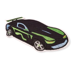 Könnte beinhalten: Schwarzer und grüner gestickter Aufnäher mit einem Rennwagen mit Spoiler. Das Auto hat eine schwarze Karosserie mit grünen und blauen Akzenten.