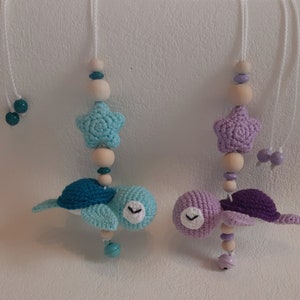 Puede incluir: Dos juguetes para beb&eacute;s de tortuga de crochet con cuentas de madera y abalorios de estrella. La tortuga de la izquierda es azul y verde, y la tortuga de la derecha es morada.