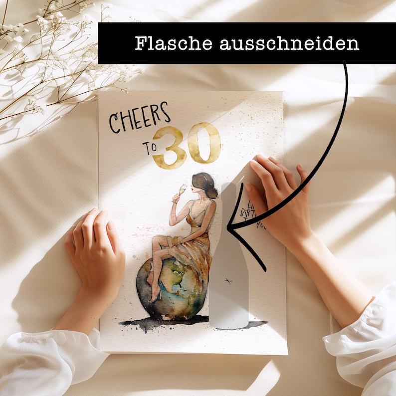 May include: A white card with the words "Cheers to 30" in black and gold lettering. A woman in a gold dress is sitting on a globe, holding a glass of champagne. The card is being held by a hand, and a bottle of champagne is being cut out of the card.