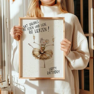 May include: A watercolor illustration of a mouse wearing a tutu and holding two glasses of champagne. The text reads "Mit Balance im Leben und Liebe im Herzen! Happy Birthday".