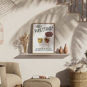 May include: A framed print with a light brown background and a cartoon illustration of two birds. The text on the print reads "Hallo Ruhestand!" and "Wir w&uuml;nschen dir alles Gute und werden dich sehr vermissen".