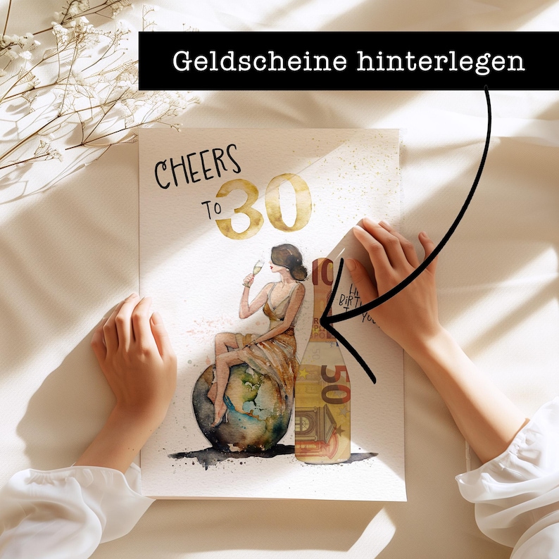 May include: A watercolor illustration of a woman holding a glass of champagne, sitting on a globe. The text "CHEERS TO 30" is written above her. The image is on a white background with a hand holding a 50 euro bill over the illustration. The text "Geldscheine hinterlegen" is written above the hand.